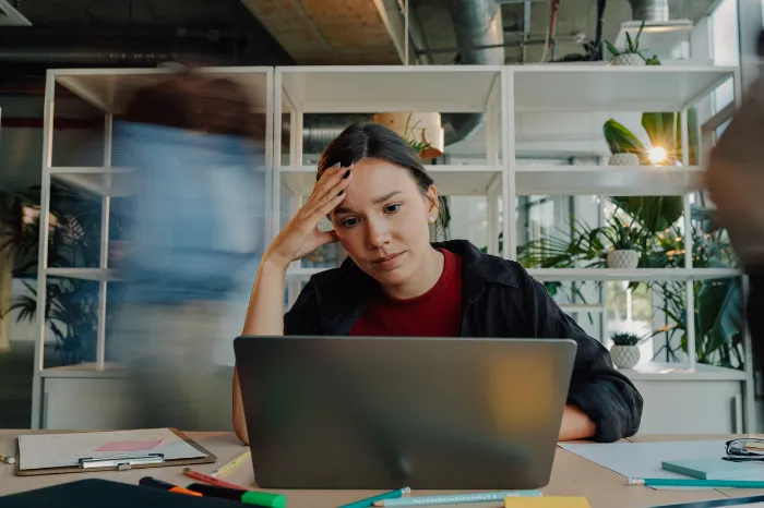 woman sitting at her laptop filled with anxiety.