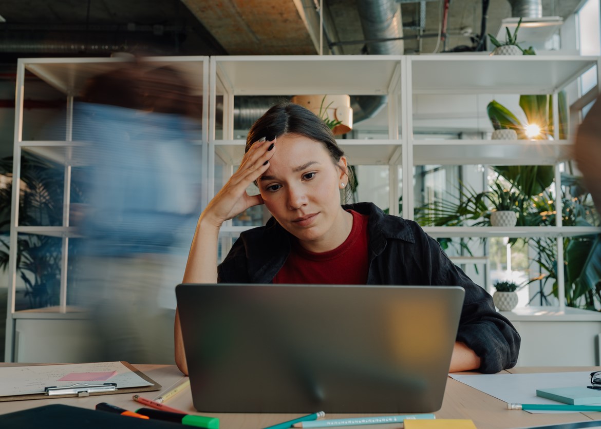 woman sitting at her laptop filled with anxiety.